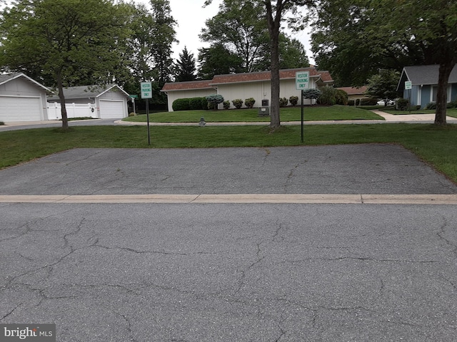 view of front facade with a front yard, a garage, and driveway