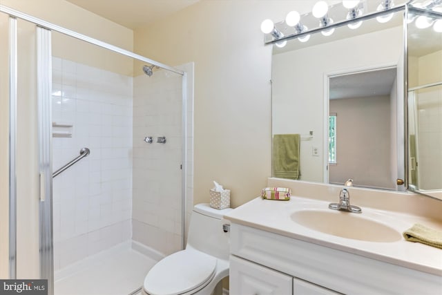 bathroom featuring toilet, tiled shower, and vanity