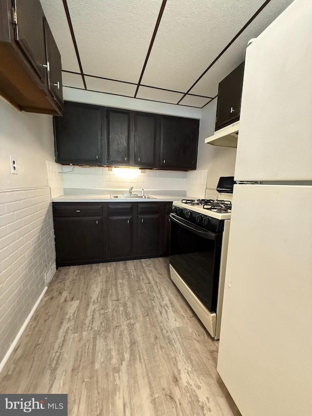 426 S Church St, Clifton Heights, PA 19018 - kitchen featuring freestanding refrigerator, gas stove, a sink, light wood-style floors, and dark cabinets