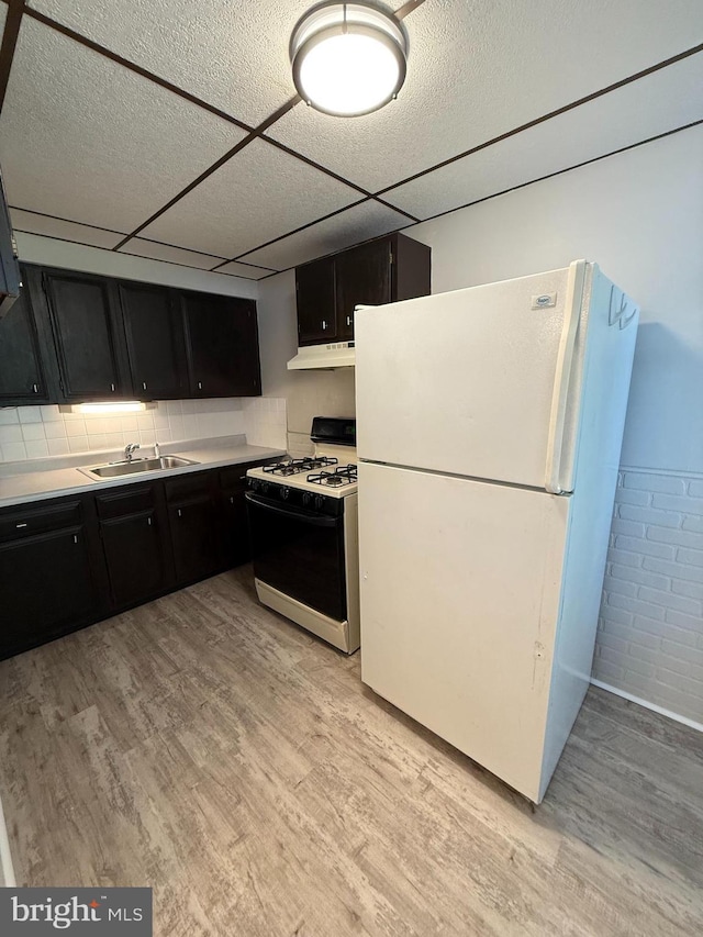 426 S Church St, Clifton Heights, PA 19018 - kitchen with freestanding refrigerator, range with gas stovetop, under cabinet range hood, a sink, and dark cabinetry
