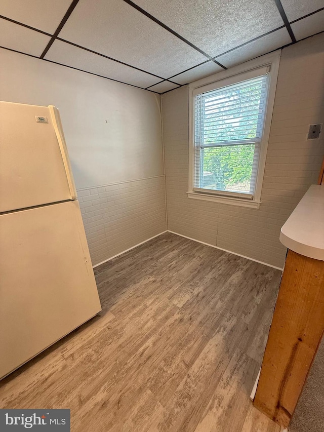 426 S Church St, Clifton Heights, PA 19018 - unfurnished dining area with a drop ceiling, wood finished floors, and brick wall