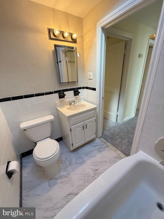 426 S Church St, Clifton Heights, PA 19018 - bathroom featuring tile walls, marble look tiles, toilet, vanity, and a tub