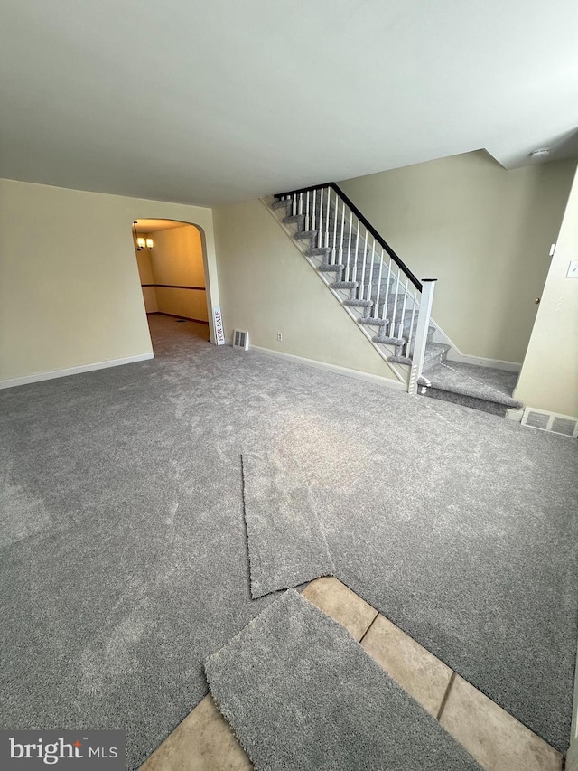 426 S Church St, Clifton Heights, PA 19018 - unfurnished living room featuring arched walkways, stairs, baseboards, and carpet