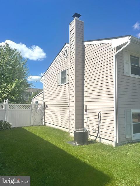 view of side of property featuring a chimney and central AC unit