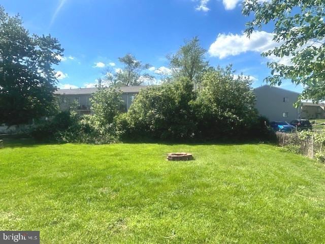 view of grassy yard with a fire pit