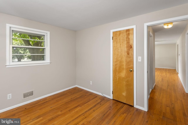 unfurnished bedroom featuring wood-type flooring and baseboards