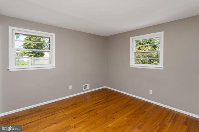 unfurnished room with baseboards and wood finished floors