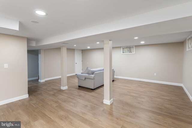 finished basement featuring baseboards, light wood-style flooring, and recessed lighting