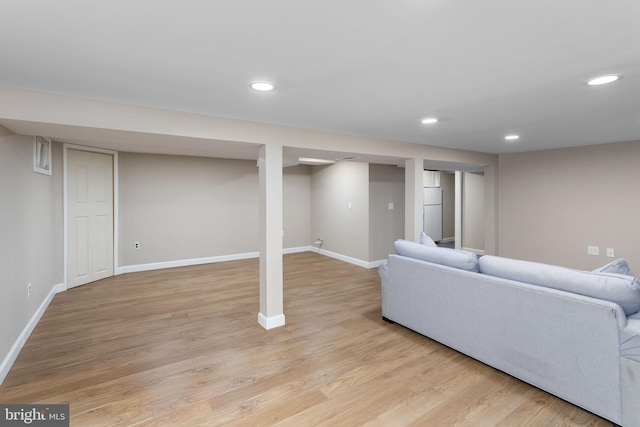 living area with baseboards, light wood-style flooring, and recessed lighting