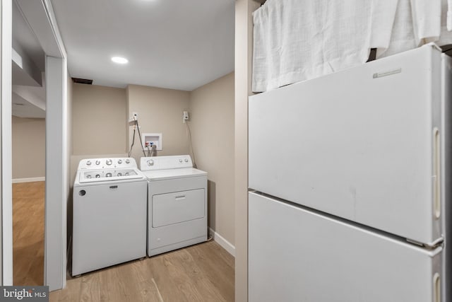 laundry room with washing machine and dryer, light wood-type flooring, baseboards, and recessed lighting