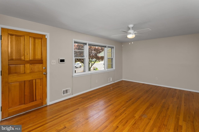 unfurnished room featuring light wood-type flooring, a ceiling fan, and baseboards