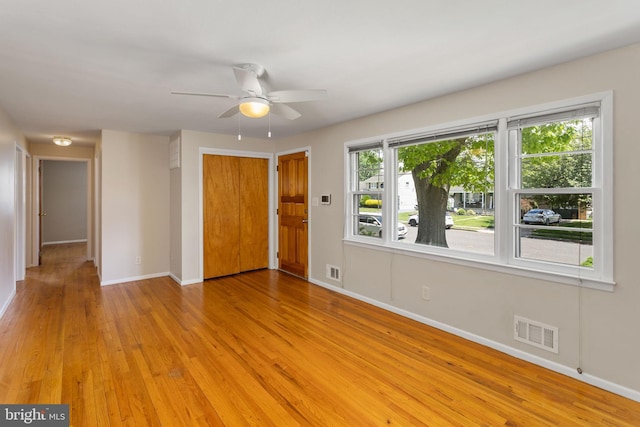 empty room with baseboards, light wood-style floors, and ceiling fan