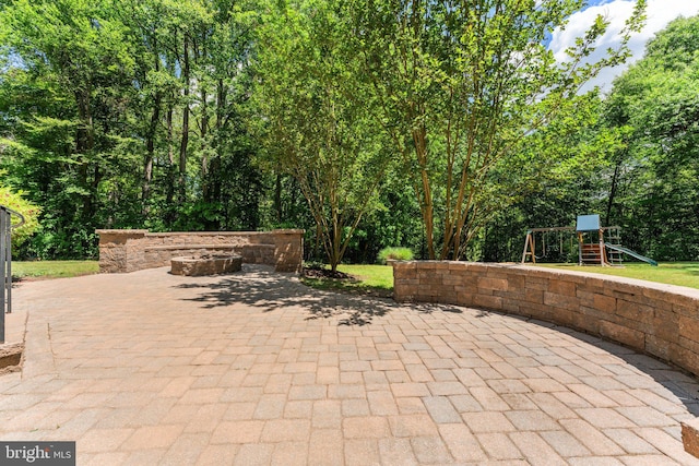 view of patio featuring a playground and a fire pit