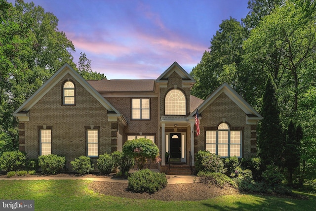 view of front of home with brick siding and a front lawn