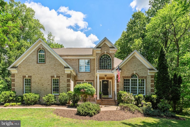 view of front of property featuring brick siding and a front lawn