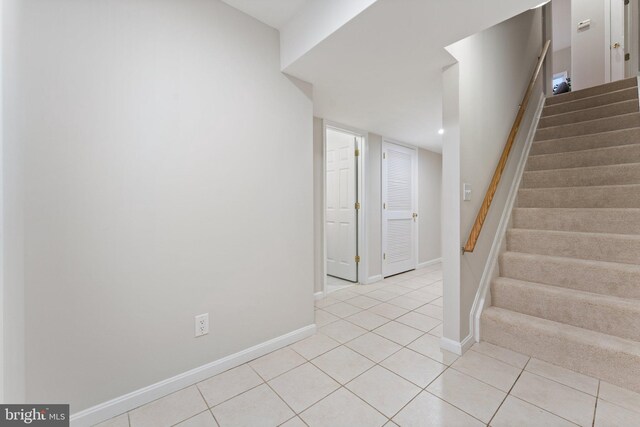 staircase featuring baseboards and tile patterned flooring