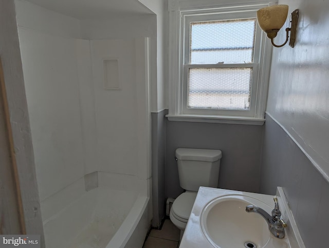 bathroom featuring a sink, toilet, and tile patterned flooring