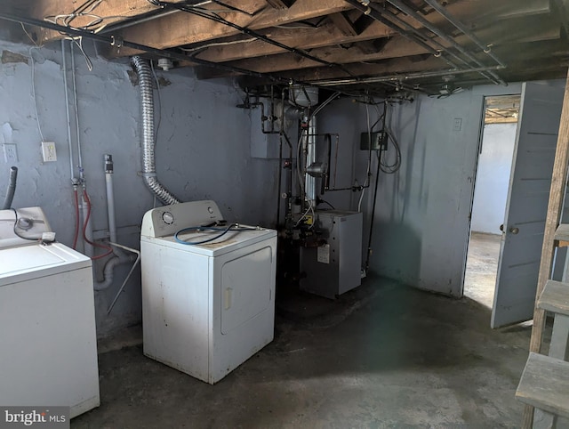unfinished basement with washer and clothes dryer and a heating unit