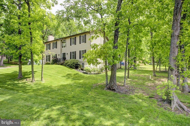 view of front of home with a chimney and a front yard