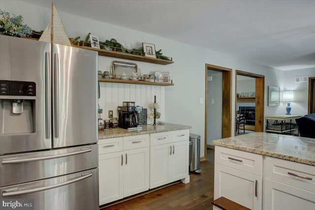 kitchen with stainless steel fridge with ice dispenser, dark wood-style flooring, white cabinets, and light stone counters