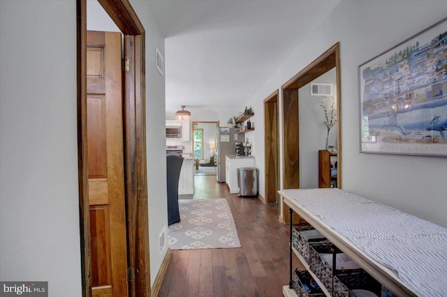 corridor featuring dark wood finished floors