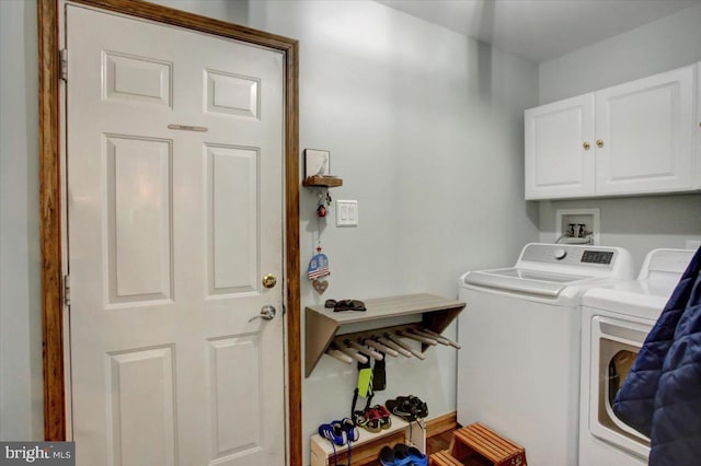 laundry area featuring washing machine and clothes dryer and cabinet space