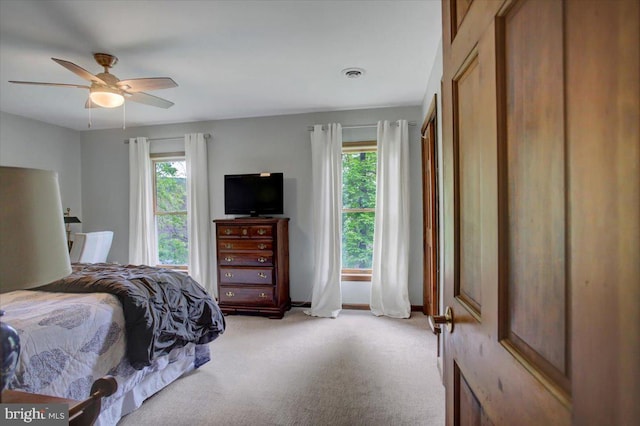 bedroom featuring light colored carpet and a ceiling fan