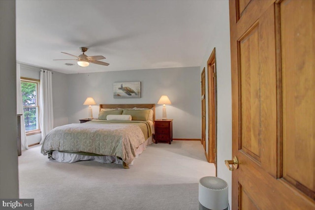 carpeted bedroom featuring a ceiling fan and baseboards