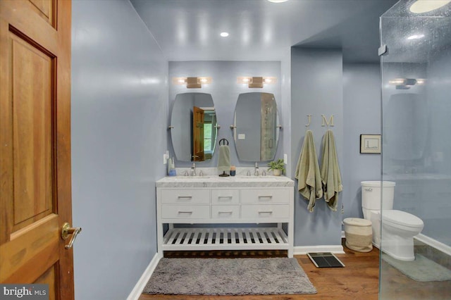 full bath featuring wood finished floors, baseboards, double vanity, and toilet