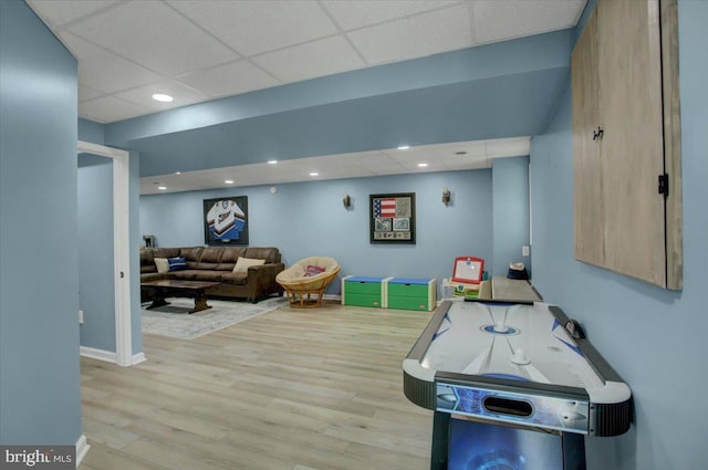 game room with wood finished floors, a drop ceiling, recessed lighting, and baseboards