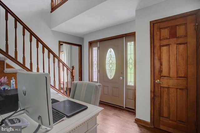 entryway featuring stairway, light wood-style floors, and baseboards