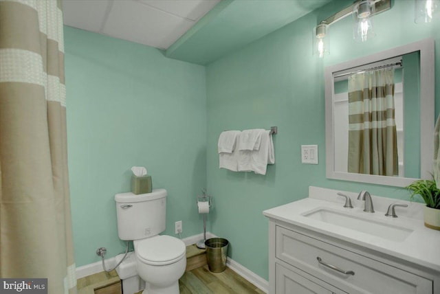 full bathroom with baseboards, toilet, vanity, wood finished floors, and curtained shower