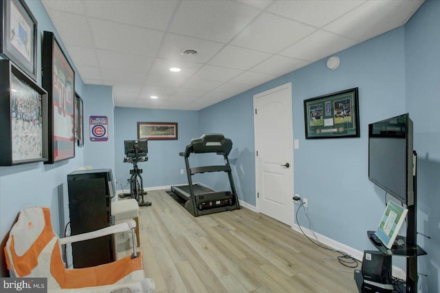 exercise room with wood finished floors, a drop ceiling, recessed lighting, and baseboards