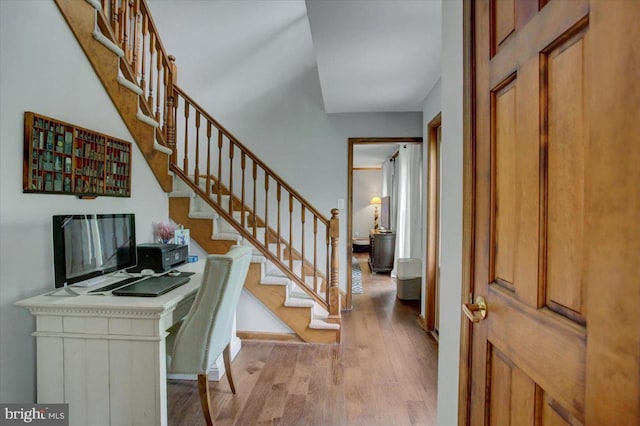 entryway featuring light wood-style floors, stairs, and baseboards