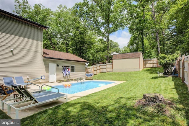 view of pool featuring view of wooded area and an outbuilding