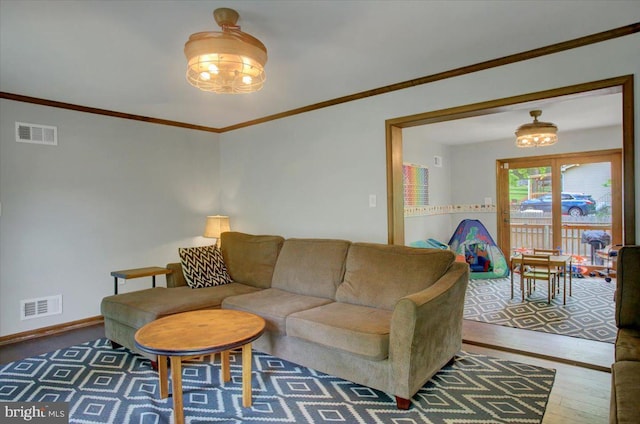 living room featuring ornamental molding, wood finished floors, and baseboards