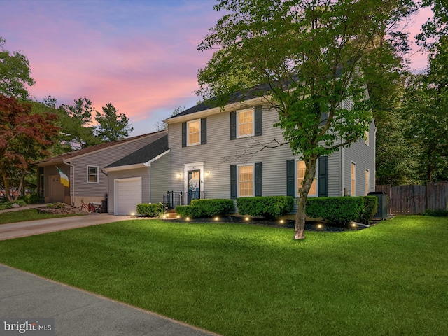 colonial-style house with a garage, driveway, and central air condition unit