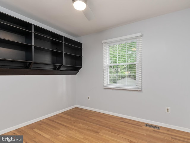 spare room featuring a ceiling fan, baseboards, and wood finished floors