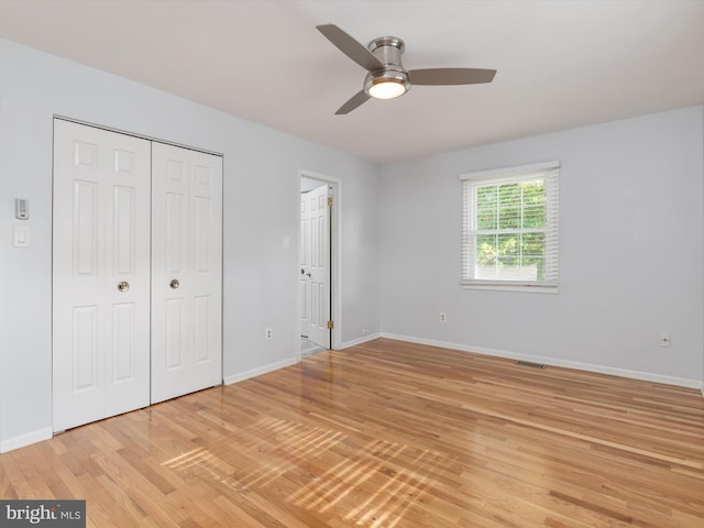 unfurnished bedroom featuring light wood-style floors, baseboards, a closet, and a ceiling fan