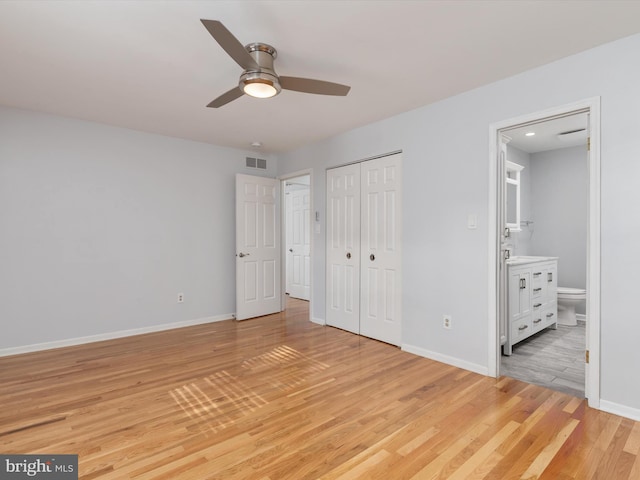 unfurnished bedroom featuring light wood-style floors, baseboards, and a closet