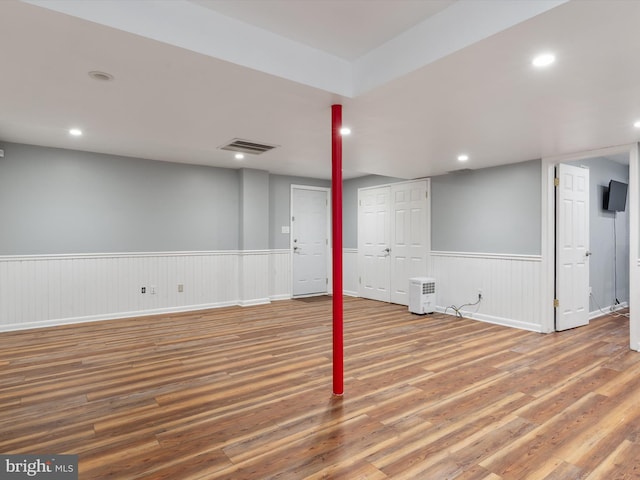 finished below grade area with wood finished floors, wainscoting, and recessed lighting