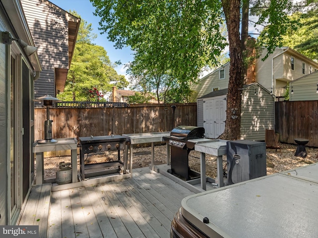 deck featuring a shed, an outdoor structure, and a fenced backyard