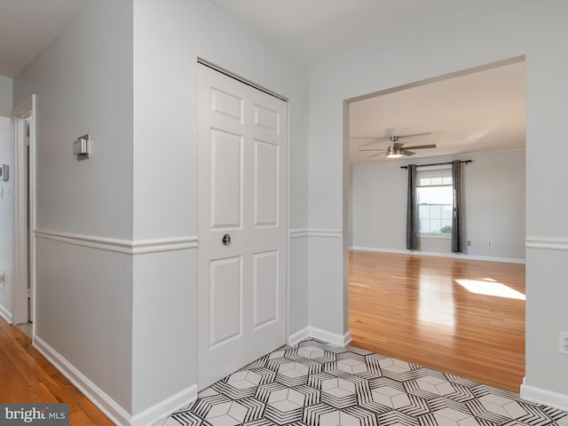 hallway featuring light wood-type flooring and baseboards