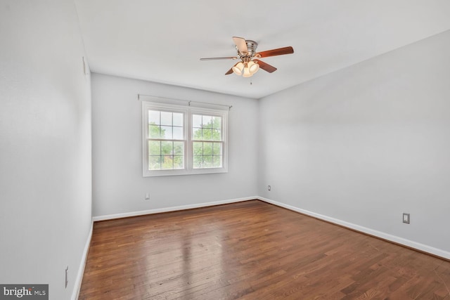 spare room with a ceiling fan, wood finished floors, and baseboards