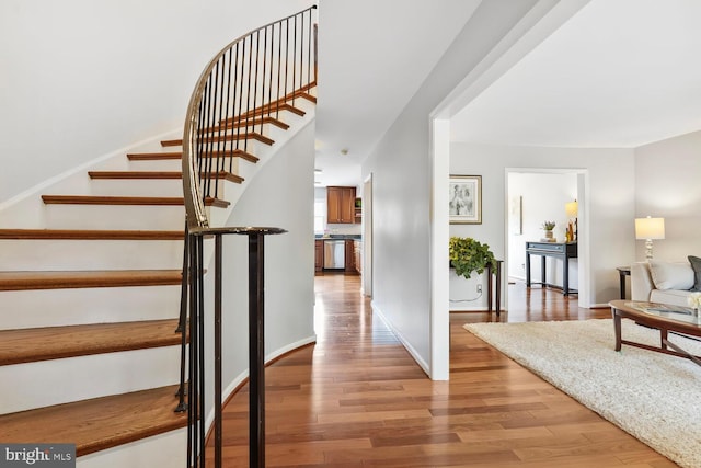 staircase with wood finished floors and baseboards
