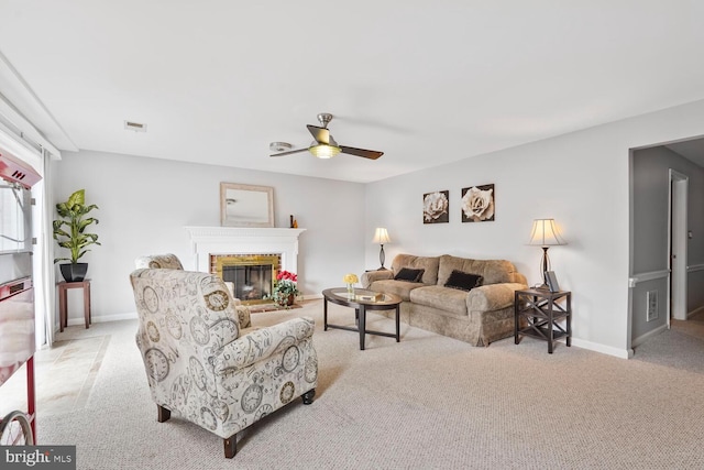 living room with carpet, ceiling fan, a brick fireplace, and baseboards