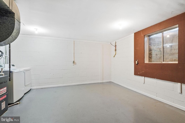 basement with concrete block wall and washer and dryer