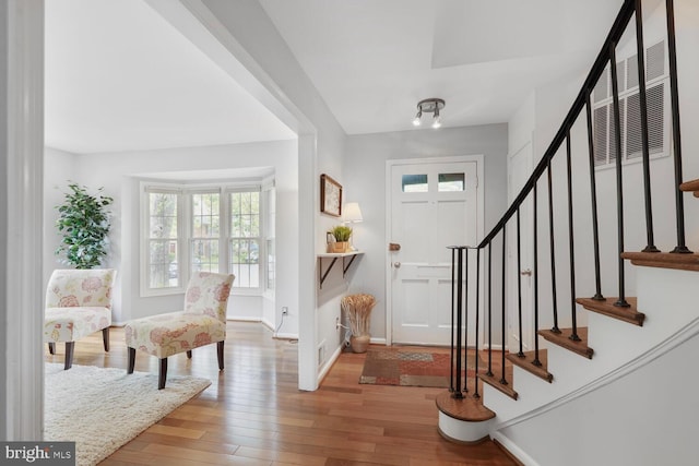 foyer featuring plenty of natural light, hardwood / wood-style floors, and stairway