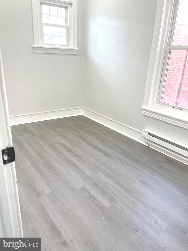 111 Oley St, Reading, PA 19601 - spare room featuring baseboard heating, wood finished floors, and baseboards