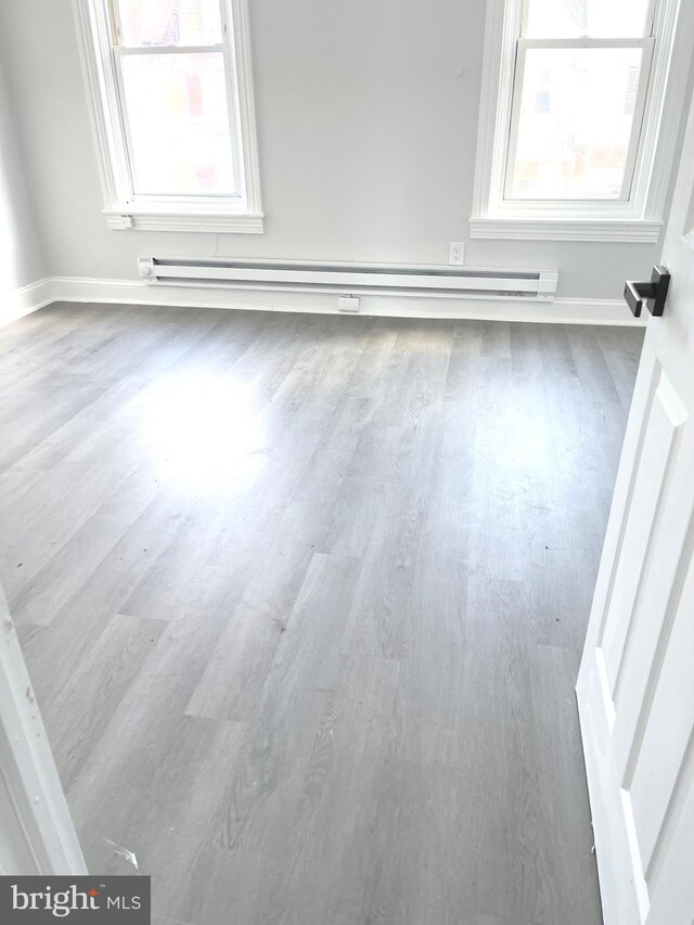 111 Oley St, Reading, PA 19601 - empty room featuring wood finished floors, a baseboard radiator, and baseboards